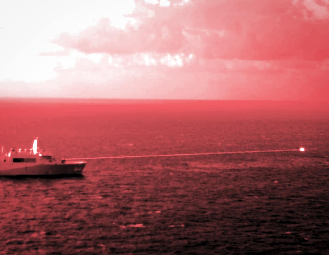 Amphibious transport dock ship USS Portland conducts a high-energy laser weapon system demonstration on a static surface training target while sailing in the Gulf of Aden. The photo was captured using a short wave infrared lens and optical filter. Courtesy of Staff Sgt. Donald Holbert, U.S. Marine Corps.