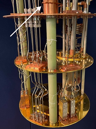 NIST physicists measured and controlled a superconducting qubit using light-conducting fiber (indicated by arrow) instead of metal electrical cables like the 14 shown here. Courtesy of Lecocq/NIST.