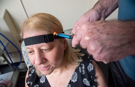 Researchers at the VA Bedford Healthcare System demonstrate how near-infrared spectroscopy is used to detect brain changes possibly linked to Alzheimer's disease. Courtesy of Frank Curran.