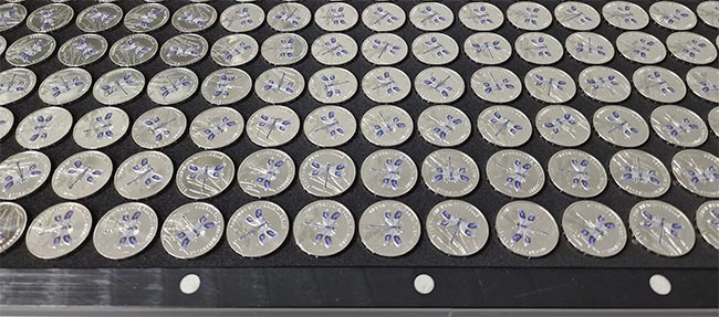Coins are laid on trays and capture data is recorded by the pvPhotobox before they are sent to the printer. The algorithm will recognize the rotation and placement of the coins to make consistent prints. Courtesy of phil-vision.