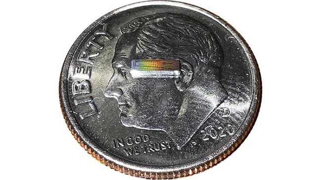 Photonic integrated chip capable of encoding data on 32 independent frequency channels on a U.S. dime for scale. Courtesy of Lightwave Research Laboratory/Columbia Engineering.