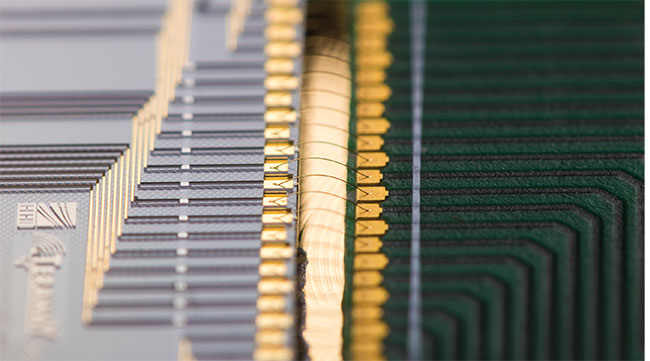 The electrical connections between a prototypical PIC and other PCB components are typically enabled by wire bonds that, to prevent shorting or sagging, should be as short and as parallel as possible. It is advisable, therefore, for these wire bonds to cross over straight from the PIC to the PCB or housing. Courtesy of PHIX Photonics.