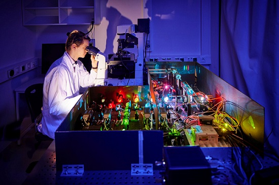 Researcher Koen Martens, from the Institute for Microbiology and Biotechnology at the University of Bonn, works at the custom-built superresolution fluorescence microscope that he uses for his investigations. Courtesy of Volker Lannert/University of Bonn.