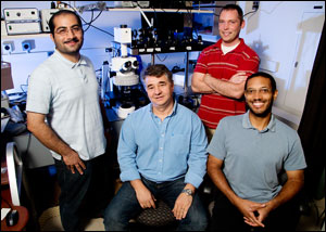 Illinois researchers, from left, graduate student Amir Arbabi, professor Gabriel Popescu, graduate student Chris Edwards and professor Lynford Goddard — use a special microscope to simultaneously etch tiny features in semiconductor wafers and monitor the process in real time.