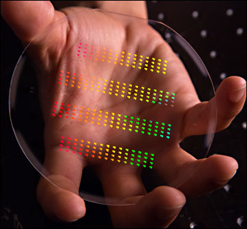 The nanoscale patterns of SLAC and Stanford's accelerator on a chip gleam in rainbow colors before being assembled and cut into their final forms. 