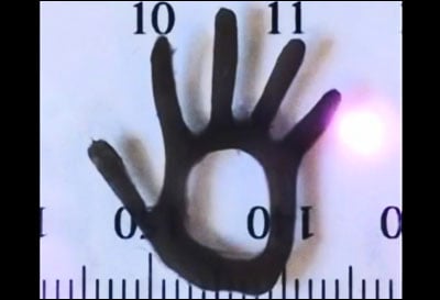 In this still from a video by Eddie Wang, a new hydrogel material shaped like a hand about 2 cm wide flexes in response to near-IR laser light.