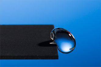 A water droplet slides off a piece of nanotextured metal. 