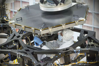 An engineer installs the first flight mirror onto the James Webb Space Telescope at NASA's Goddard Space Flight Center in Greenbelt, Md.