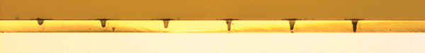 A 50-&micro;m-thick glass substrate drilled with successively more pulses from a CO laser demonstrates the ability of this source to drill glass interposers, as well as drill micro dots on light guide panels used in display backlights.