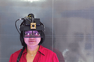 University of Arizona professor Hong Hua wears a head-mounted projection display system, which integrates 3D head-tracking sensors and hand-gesture recognition cameras to enable natural navigation and user interaction in augmented reality environments.