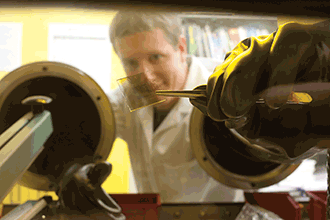 University of Arizona PhD student Byron Cocilovo holds an organic solar cell made in professor Robert A. Norwood’s photonics laboratory at OSC.