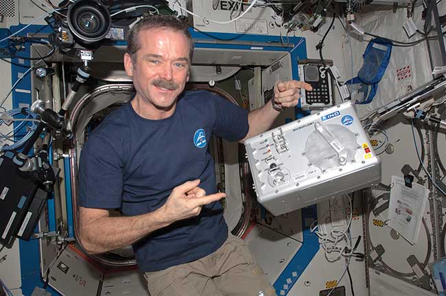 Canadian Space Agency astronaut Chris Hadfield, floating in the International Space Station, together with INO’s Microflow cytometer.