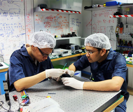 Ph.D. students Zhongkan Tang (left) and Rakhitha Chandrasekara (right) at the Centre for Quantum Technologies, National University of Singapore, are pictured working on a SPEQS unit. 