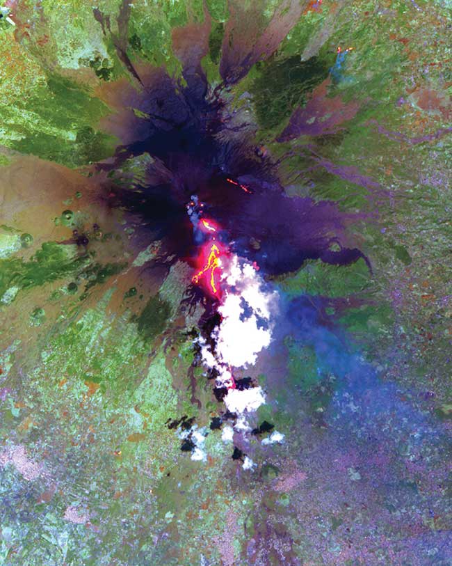 This image was acquired by NASA’s Terra satellite in July 2011 and shows advancing lava flows on the southern flank of Mt. Etna above the town of Nicolosi in Sicily, Italy, which is potentially threatened if the eruption increases in magnitude. 