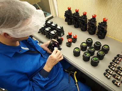 Assembly technician inspects components of Qioptiq thermal weapon sight components.