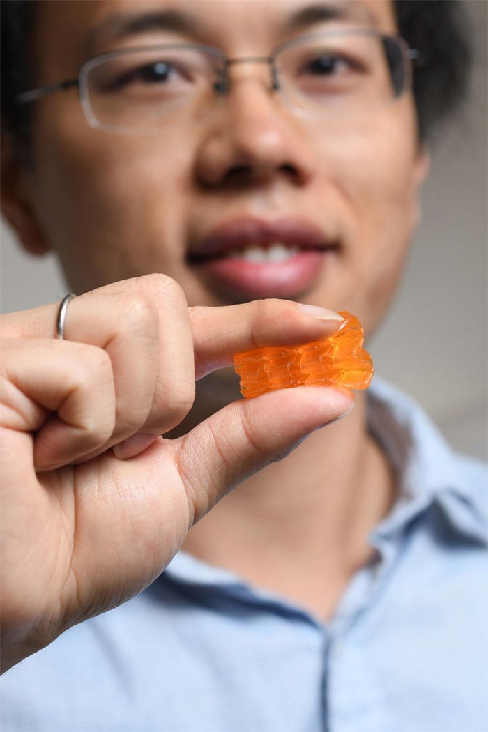 Georgia Tech postdoctoral fellow Xiao Kuang demonstrates the compressibility of origami structures created through Digital Light Processing 3D printing. Georgia Tech.