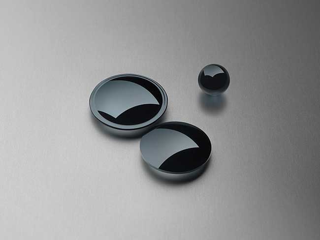 Precision-molded IR lenses and a ball preform made from chalcogenide glass.