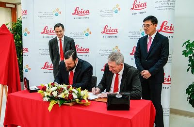 Justin L. Mynar (left, sitting) associate vice president for research and executive director of the KAUST Core Labs, and Julian Burke, chief scientific officer at Leica Microsystems, sign an agreement to inaugurate the new KAUST-Leica Center of Excellence (CoE) in Optical Microscopy on the University's campus. Walid Beylouni (left standing) and Kun Li look on during the signing ceremony. Courtesy of KAUST 2018.