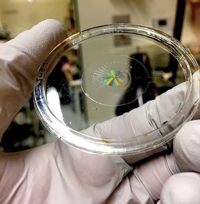 A prototype artificial eye positions a metalens on an elastomer sheet that enables applied voltage to control focus, zoom, and astigmatism, with potential in future AR/VR systems.