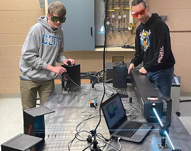 CCCC students Dylon Dierolf and Koin McDuffie set up a lab for an argon-krypton laser. Courtesy of LASER-TEC.