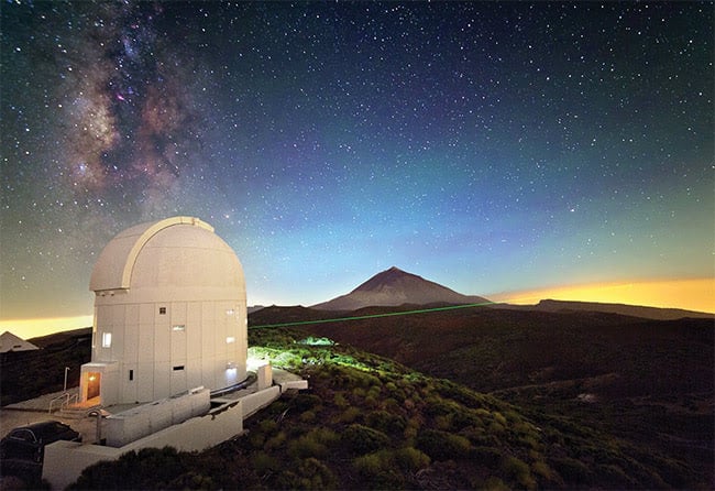 A laser from Tenerife, Spain, connects with a satellite in orbit, providing an optical data path. Courtesy of European Space Agency.