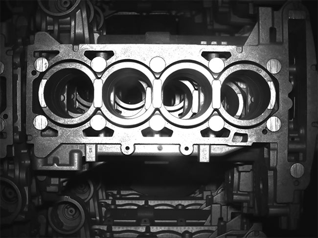 An engine block (top must be inspected for pores (bottom) and other defects. Flexible camera positioning solves this challenging vision task. Courtesy of LEONI Engineering Products and Services.