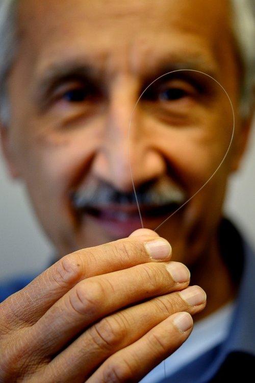 Jas Sanghera, U.S. Naval Research Laboratory branch head for Optical Materials and Devices, holds up an optical fiber that will be used to produce eye-safer lasers at U.S. NRL. Courtesy of Jonathan Steffen/U.S. Naval Research Laboratory.