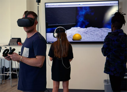 Student programmer/developer Tim Lukau (r) stands by as two students simultaneously explore the Nano 2020 environment. Courtesy of the University of Arizona.