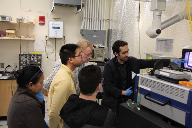 (r) to (l): Professor Samuel Serna trains Joseph Coffey, an engineer at CommScope; Shengtao Yu, a graduate student from Georgia Institute of Technology; and Liron Gantz, an engineer from Mellanox, to characterize integrated photonic devices. Courtesy of MIT.