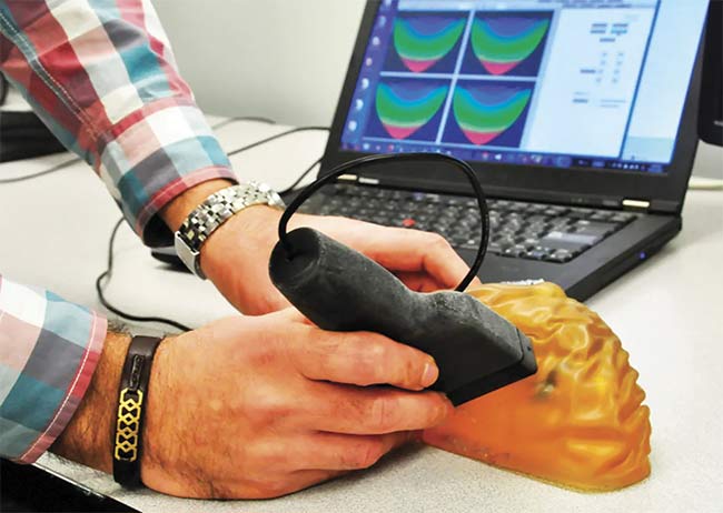 Figure 5. The SFU team’s device uses low-frequency light emitted from a hand-held probe to detect the presence of cancerous tissue in the breast (testing on a phantom). Courtesy of Simon Fraser University.