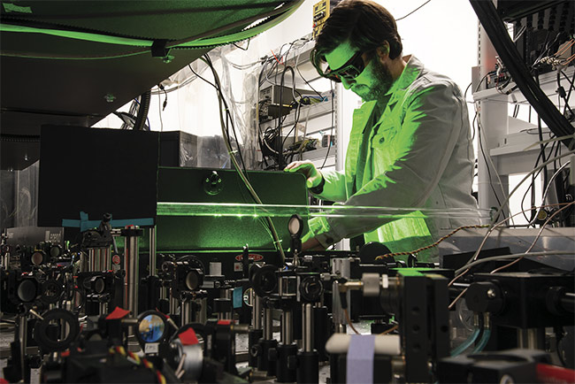 Figure 2. Researcher Seth Lieberman makes adjustments to a laser experiment in the Schaffer-Nishimura Lab at Cornell University. Courtesy of Seth Lieberman/Cornell University.