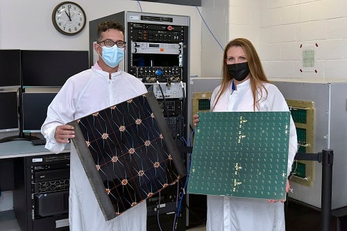 Project managers James Winter of AFRL and Tara Theret of Northrop Grumman hold models of the photovoltaic and radio frequency sides of the sandwich tile. Courtesy of Northrop Grumman. 