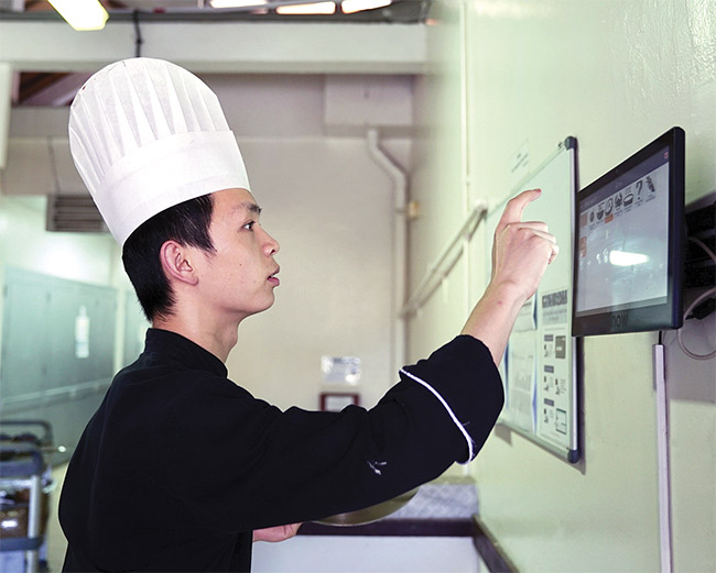 Kitchen staff use a touchscreen to make selections in the Winnow Vision food waste reduction system. Courtesy of Winnow.