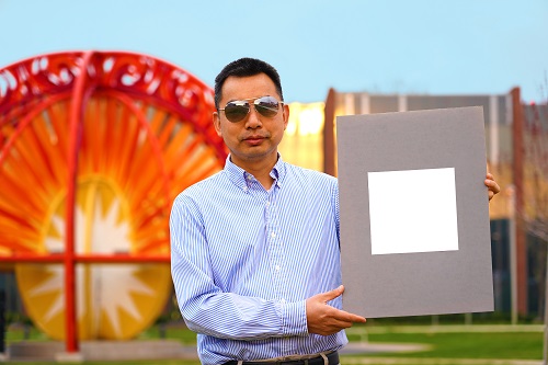 Xiulin Ruan, a Purdue University professor of mechanical engineering, holds up his lab's sample of his team's whitest paint. Courtesy of Purdue University/Jared Pike.