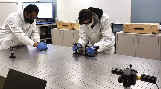 Fikralem Gebremedhin (left) and Nathan Suss set up a laser/optical experiment in the photonics lab at Lake Washington Institute of Technology.
