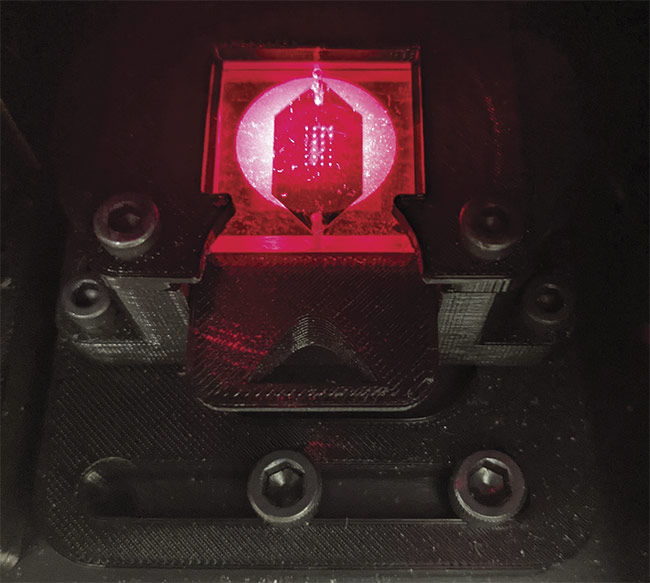Figure 2. An illuminated biochip, based on grating-coupled fluorescent plasmonics (GC-FP) technology, undergoing analysis. The biochip can be scored using an algorithm to diagnose Lyme disease and potentially other conditions as well. Courtesy of Nathaniel Cady.