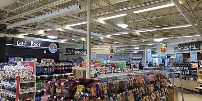 Cameras and edge computing mounted in rails near the overhead lights enable retail customers to check out without visiting a cashier or a self-checkout station. The technology also simplifies inventory control and reduces losses. Courtesy of Store GetGo and Grabango.