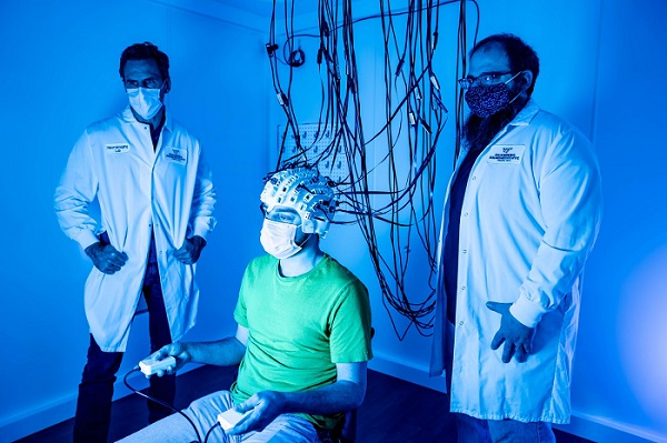 Professor Read Montague (l) and professor Stephen LaConte (r) work with research assistant Chris Huck to demonstrate the new optically pumped magnetometry technology. Montague and LaConte received a $2.4 million NIH grant to explore the neural underpinnings of face-to-face interactions. Courtesy of Clayton Metz/Virginia Tech.