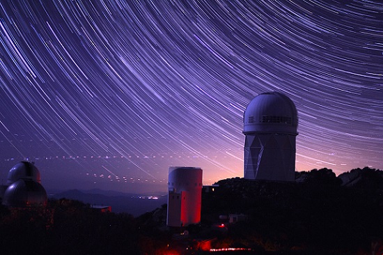 Star trails take shape around the 14-story Mayall Telescope dome in this long-exposure image. The Dark Energy Spectroscopic Instrument was installed inside this dome. Courtesy of P. Marenfeld and NOAO/AURA/NSF.