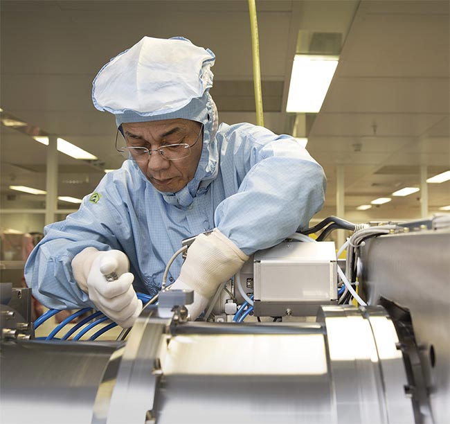 An engineer assembles an illumination module for a DUV lithography system. Improvements to DUV light sources are supporting rather than detracting from the wider adoption of EUV lithography systems. Courtesy of ASML.