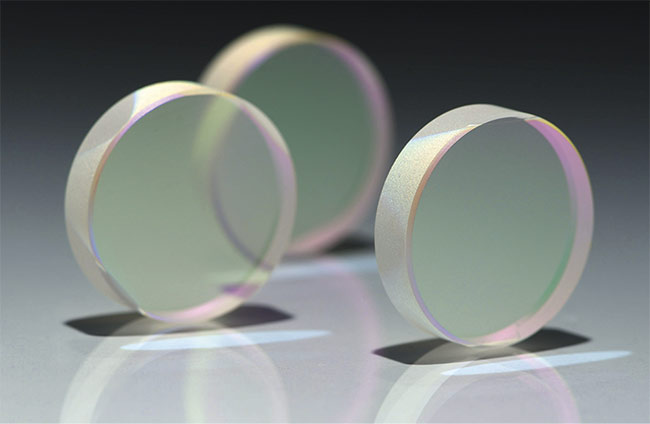 Circular optics. The surface flatness of so-called flat optics is influenced by the shape of the component. Circular optics, for example, tend to achieve flatter surfaces than elliptical shapes, and this pattern continues respectively through square and rectangular formats and odd custom shapes such as trapezoids. Courtesy of PFG Precision Optics.