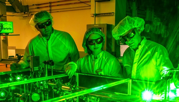 Berkeley Lab doctoral student Fumika Isono (center), BELLA Center Deputy Director Jeroen van Tilborg (right), and research scientist Sam Barber set up a novel laser stabilization experiment at one of the BELLA Center’s 100-TW-class lasers. Courtesy of Marilyn Sargent/Berkeley Lab.