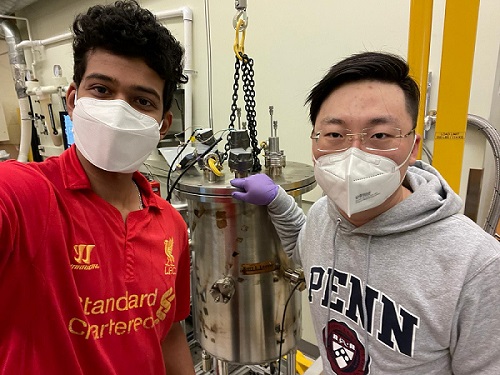 Shivajee Govind (left), a Ph.D. student in the lab of Zahra Fakhraai, and Yi Jin, study lead author and recent Ph.D. graduate, standing by the ultra-high vacuum chamber that the researchers use to deposit glass thin films. Courtesy of Zahra Fakhraai, Pennsylvania State University.