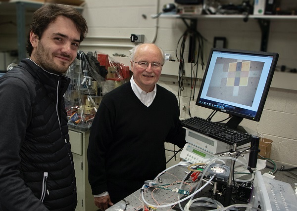 MIT professor Harry L. Tuller (right), graduate student Thomas Defferriere, and colleagues have shown how light can boost the performance of lithium batteries, fuel cells, and other devices based on the movement of charged atoms, or ions. Courtesy of Denis Paiste, MIT Materials Research Laboratory. 