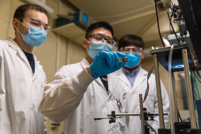 From left, PhD student Aidan Maxwell, postdoctoral fellow Hao Chen, and postdoctoral fellow Chongwen Li from the Department of Electrical and Computer Engineering at the University of Toronto demonstrate their prototype all-perovskite tandem solar cell at their testing facility. Courtesy of Aaron Demeter/ University of Toronto Engineering.