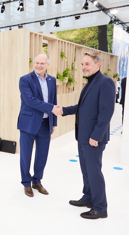 Martin Schenk, senior vice president product management SICK (right) and MVTec's managing director Olaf Munkelt shake hands after signing the agreement at the SPS trade fair in Nuremberg. Courtesy of MVTec.
