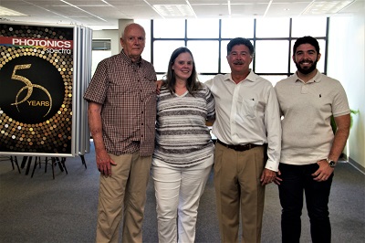 Bruce Walker (left) and his daughter, Laurie, with Photonics Media president Tom Laurin (second from right) and vie president Erik Laurin (right) during a 2019 visit. 