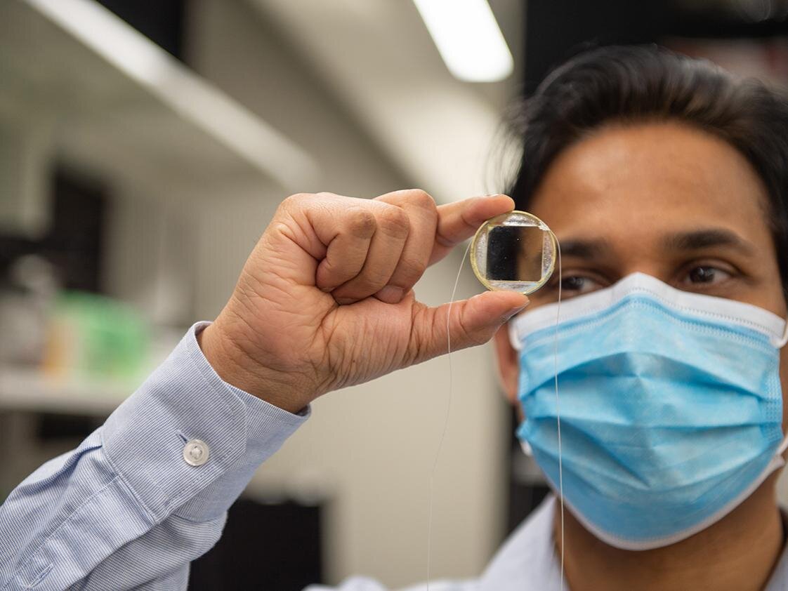 Sri-Rajasekhar “Raj” Kothapalli, assistant professor of biomedical engineering at Penn State, holds an optically transparent, biocompatible ultrasound transducer chip. The technology has implications for future cancer and stem cell research. Courtesy of Kelby Hochreither, Penn State.