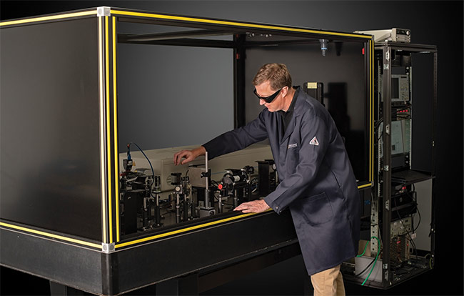 Matthew Dabney, principal laser engineer at Edmund Optics, tests the laser-induced damage threshold of optical components in a specially designed laser lab. Courtesy of Edmund Optics.