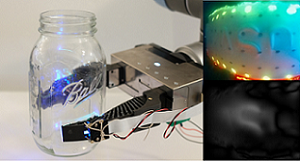 The GelSight Fin Ray gripper holds a glass Mason jar with its tactile sensing. The soft robotic gripper features an embedded camera and sensory capabilities. Courtesy of MIT CSAIL. 